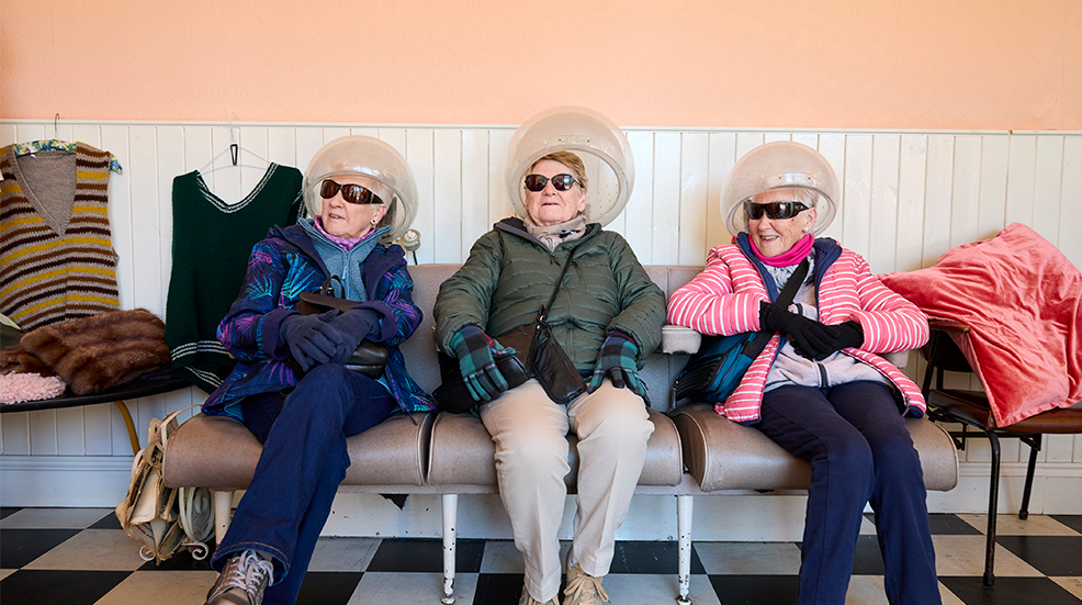Three elderly women sit in a row at the Beamish hair salon, The Living Museum of the North